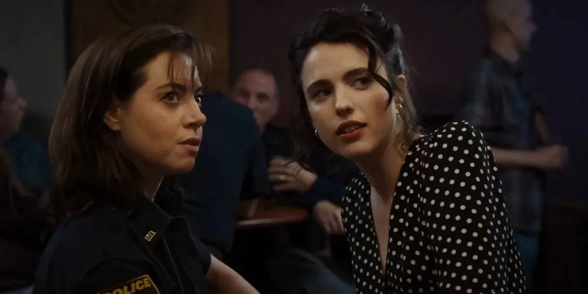 Aubrey Plaza e Margaret Qualley como personagens de "Honey Don't!", olhando para algo/alguém em um ponto longe da câmera, uma inclinada para a outra.