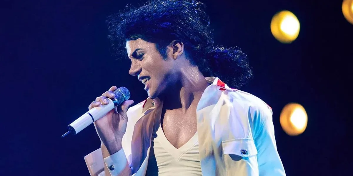 Cinebiografia de Michael Jackson Passará por Refilmagens e Pode ser Dividido em Duas Partes Jaafar Jackson como Michael Jackson na cinebiografia do artista, prevista para 2025, "Michael". O cantor está de camisa e camiseta branca, segurando um microfone branco com a mão direita, inclinado com a cabeça para a direita à esquerda da tela, e cabelo longo preso.