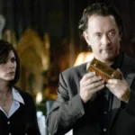 Audrey Tautou, esquerda, e Tom Hanks, direita, segurando um objeto dourado em "O Código Da Vinci", longa de 2006.
