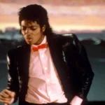 Michael Jackson em 1982 durante o clipe de "Billie Jean", dajçando com um cenário de pôr do sol ao fundo.
