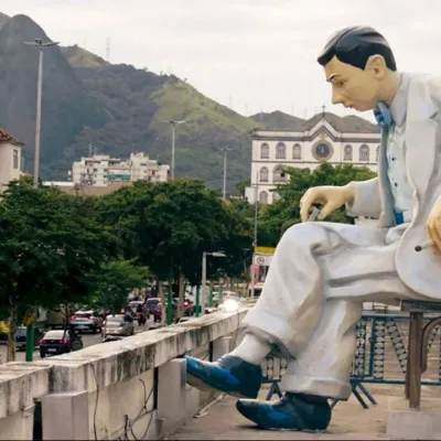 Uma estátua de Noel Rosa no Rio de Janeiro, conforme vista no documentário "Noel Rosa: Um Espírito Circulante".