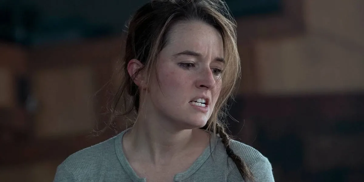 The Last of Us | 3ª Temporada Focará em Abby Como Protagonista Kaitlyn Denver como Abby da série "The Last of Us". Cabelo bagunçado, boca aberta e dentes semicerrados, raiva, hesitação, sendo focada na tela.