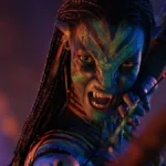 Na'vi em terceiro filme de Avatar, "Fogo e Cinzas", de 2025, segurando um arco e flecha com uma cara irritada.
