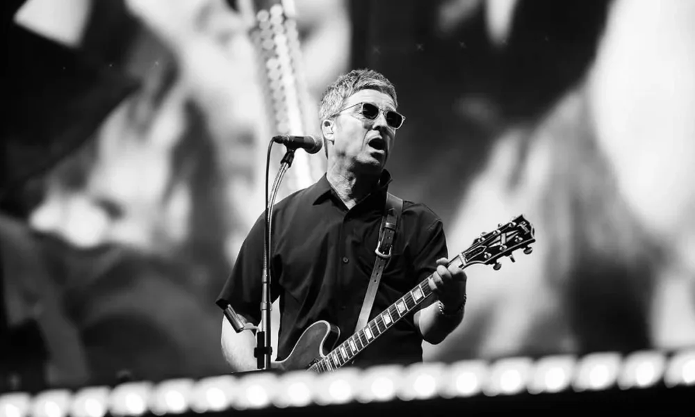 Noel Gallagher na guitarra em show do Oasis em Manchester em 12/07/2025. Imagem em preto e branco.