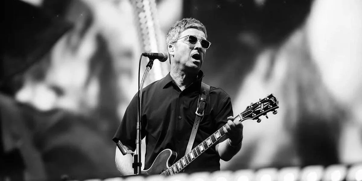 Noel Gallagher na guitarra em show do Oasis em Manchester em 12/07/2025. Imagem em preto e branco.