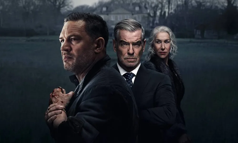 Tom Hardy a frente, de perfil, com Pierce Brosnan atrás e, por fim, Helen Mirren, matriarca da família, na série "Terra da Máfia". Palheta cinzenta, mas em cores, com uma casa cinza ao fundo e um gramado verde triste.