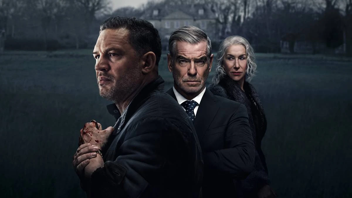 MobLand – Terra da Máfia | Série Surpreende com Caos, Loucura e Violência em Batalha de Gangsters na Londres Contemporânea 2 Tom Hardy a frente, de perfil, com Pierce Brosnan atrás e, por fim, Helen Mirren, matriarca da família, na série "Terra da Máfia". Palheta cinzenta, mas em cores, com uma casa cinza ao fundo e um gramado verde triste.