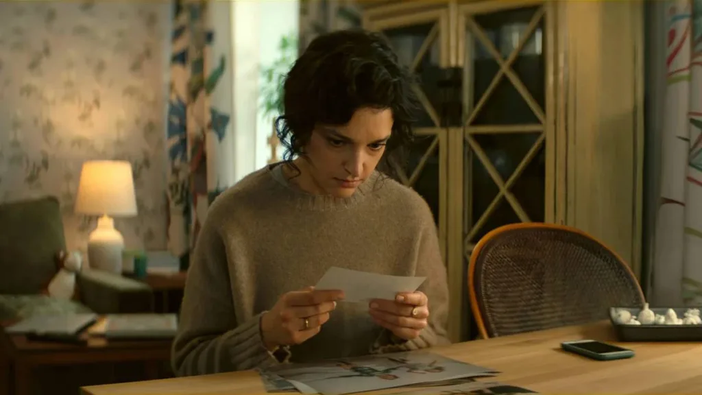 Apenas Um Olhar | Mais Uma Minissérie da Netflix Baseada Nos Sucessos Literários de Harlan Coben 1 Maria Dębska como Greta Rembiewska, preocupada com um papel na mão, em casa, sentada, de suéter, cabelo preso. Série "Apenas um Olhar".