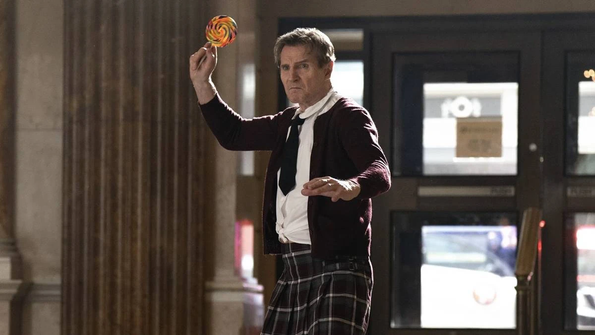 Corra Que A Polícia Vem Aí | Mais Um Reboot/Continuação que Volta Para Desafiar o Tempo e a Memória 2 Liam Neeson vestindo kilt, roupa social e gravata, empunhando um pirulito gigante colorido como se fosse uma arma de arremesso no reboot de 2025 de "Corra Que a Polícia Vem Aí".