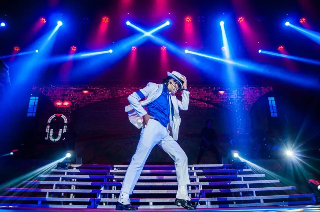 Tributo ao Rei do Pop | A Grandiosidade de Rodrigo Teaser em Cena 1 Imagem de Rodrigo Teaser no espetáculo "Tributo ao Rei do Pop", com trajes brancos de Michael Jackson.