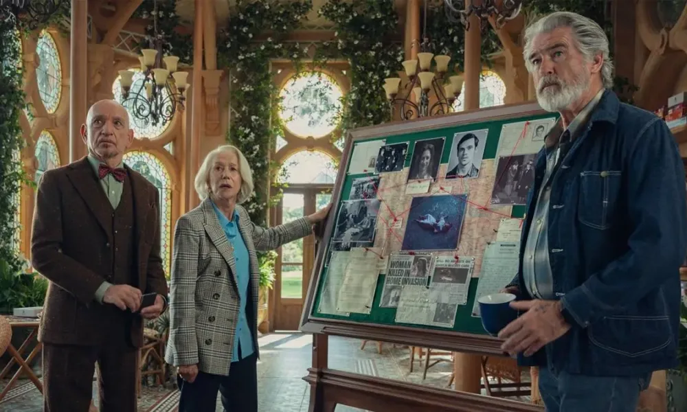 Na esquerda e mais ao fundo: Ben Kingsley e Helen Mirren, que segura o quadro, e à direita do quadro e mais à frente Pierce Brosnan. Atores interpretam seus personagens em "O Clube do Crime das Quintas-feiras", da Netflix, e estão ao lado de um quadro verde com mapa mental para resolução criminal, cheio de colagens, e olham para um mesmo ponto do outro lado da tela.