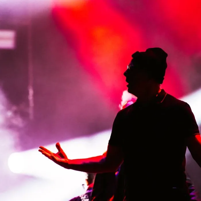 Silhueta do vocalista do Bad Religion, vista sob luz vermelha atrás dele em apresentação no palco Skyline no The Town 2025.