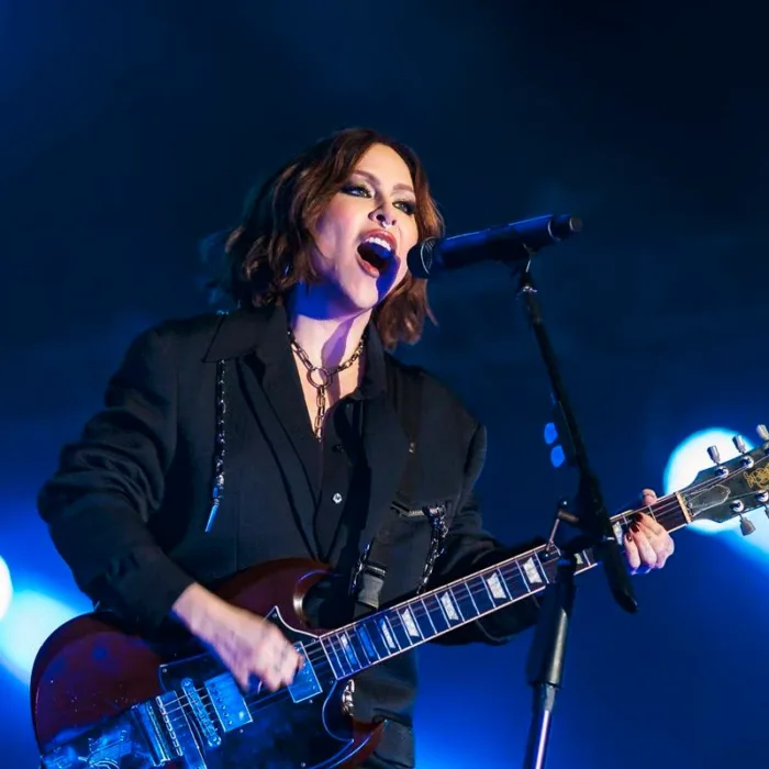 Pitty, corte chanel, maquiagem forte, roupa preta, tocando guitarra e se apresentando no palco The One no The Town 2025.