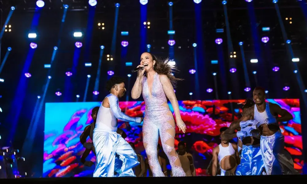 Ivete Sangalo no palco Skyline no sábado do The Town 2025. Cantora está ligeiramente curvada entre um salto e outro, cantando energicamente e cercada de seus bailarinos.