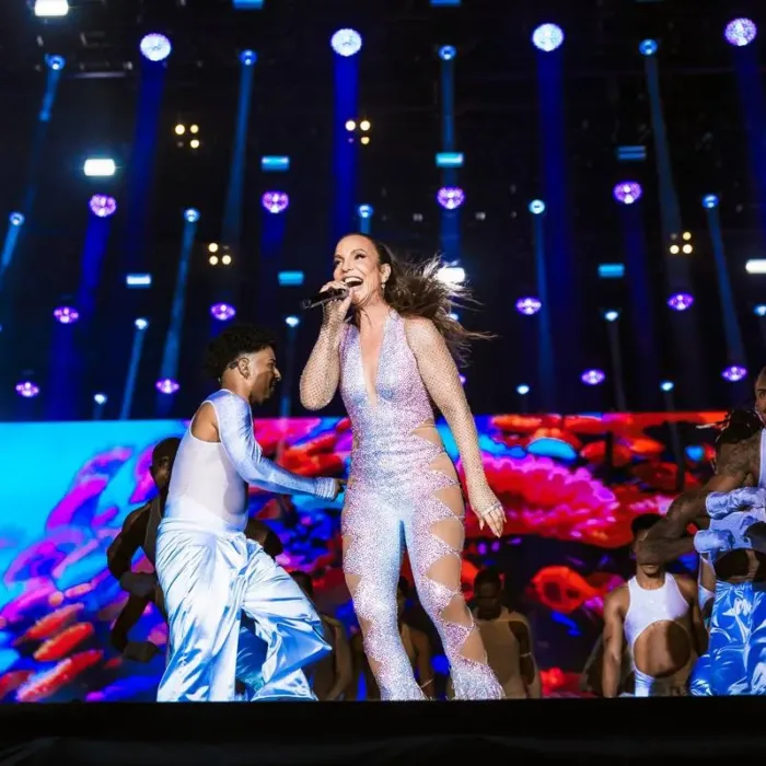 Ivete Sangalo no palco Skyline no sábado do The Town 2025. Cantora está ligeiramente curvada entre um salto e outro, cantando energicamente e cercada de seus bailarinos.