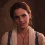 Emma Watson como a protagonista Bela de "A Bela e a Fera", live-action de 2017. Ela está com roupas de camponesa e um sorriso de canto de boca.