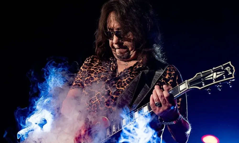 Ac Frehley tocando guitarra em show em 2025. Fumaça de glicerina pode ser vista no palco, ele com um semblante concentrado.