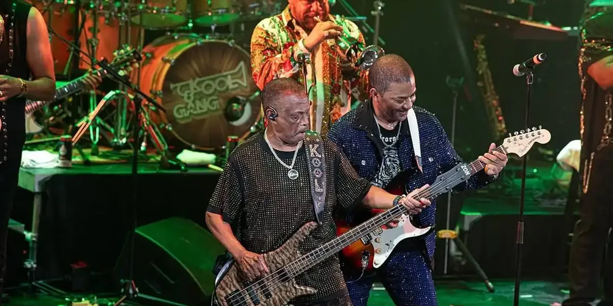 Kool & The Gang se apresentando no Ultimate Disco Cruise em 2025. Palco está iluminado com luzes verdes.