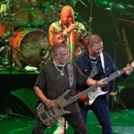 Kool & The Gang se apresentando no Ultimate Disco Cruise em 2025. Palco está iluminado com luzes verdes.