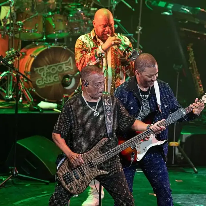 Kool & The Gang se apresentando no Ultimate Disco Cruise em 2025. Palco está iluminado com luzes verdes.