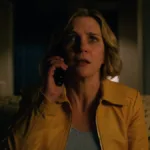 Rhea Seehorn como a protagonista de "Pluribus" com um telefone no ouvido e uma expressão de quem recebe uma notícia com espanto.