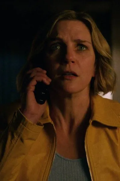 Apple TV | Veja Estreias de Novembro de 2025 Rhea Seehorn como a protagonista de "Pluribus" com um telefone no ouvido e uma expressão de quem recebe uma notícia com espanto.