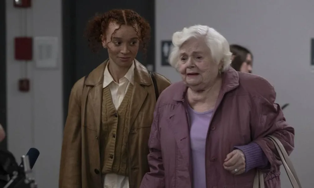 Erin Kellyman e June Squibb como Nina e Eleanor no longa "A Incrível Eleanor". Elas estão lado a lado, caminhando, a mais jovem olhando a mais velha, que dá um olhar meio distante.