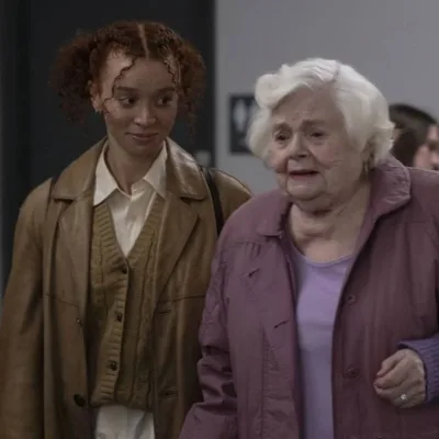 Erin Kellyman e June Squibb como Nina e Eleanor no longa "A Incrível Eleanor". Elas estão lado a lado, caminhando, a mais jovem olhando a mais velha, que dá um olhar meio distante.