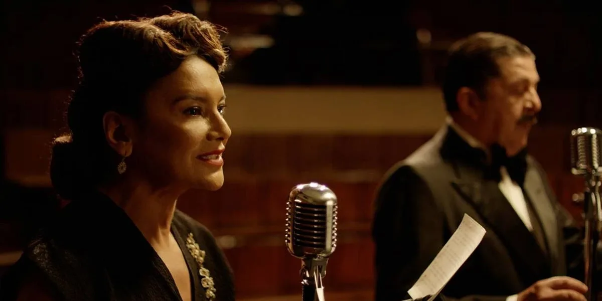 Imagem do filme "Ary", biografia de Ary Barroso, com destaque na foto para personagem retratada por Dira Paes à esquerda em frente a microfone.