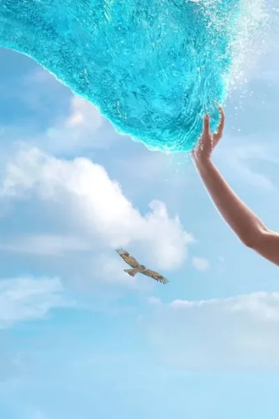 Catherine Laga‘aia como Moana no live action de 2026. Ela está no canto inferior direito tocando o mar que se move até ela como um tentáculo brilhante, ocupando a maior parte da tela.