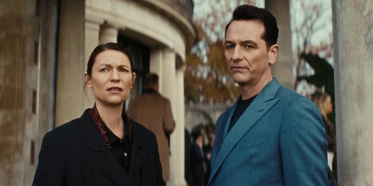 O Monstro Em Mim | É a Netflix Acertando Mais Uma Vez no Entretimento Semanal Claire Danes como Agatha 'Aggie' Wiggs e Matthew Rhys como Nile Jarvis, um ao lado do outro, olhando como se recalculassem a rota, de pé, na frente de um prédio de estrutura clássica na série "O Monstro em Mim".