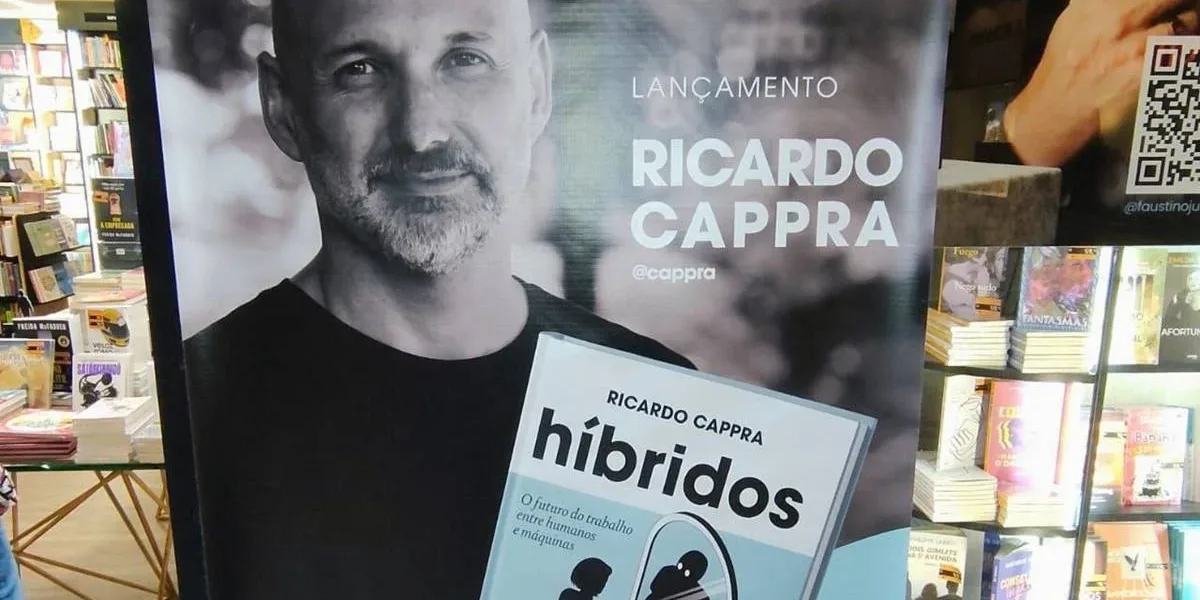 Pôster com autor Ricardo Cappra em matiz sépia segurando livro "Híbridos" em lançamento.