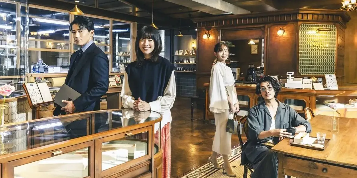 Quatro protagonistas de "Românticos Anônimos" na fictícia chocolataria da série, posando como seus personagens.