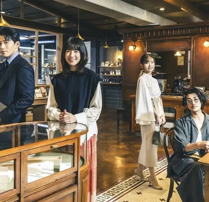 Quatro protagonistas de "Românticos Anônimos" na fictícia chocolataria da série, posando como seus personagens.