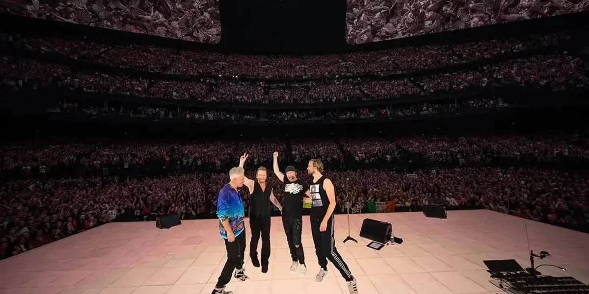 U2 | Prefeitura do Rio Confirma Show de Graça e Apaga; Entenda Membros do U2 em show Live at Sphere em 2024, de costas para o palco, tirando foto com o público.