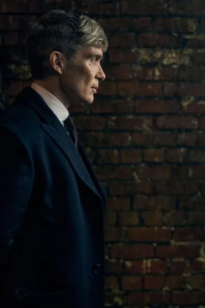 Peaky Blinders: O Homem Imortal | Netflix Lança Trailer do Fim da Saga Cillian Murphy caracterizado como Thomas Shelby para o filme de fechamento da franquia "Peaky Blinders", ambientado na 2ª Guerra Mundial, "O Homem Imortal". Ele está de perfil, mãos para trás, com um muro de tijolos ao fundo.