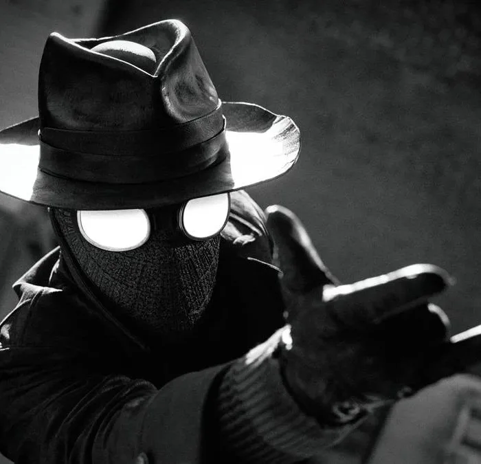 Homem Aranha Noir em série homônima da Prime Video, vestido o traje preto, sobretudo, e um chapéu de investigador em imagem em preto e branco no estilo de filmes policíacos dos anos 30 e 40.
