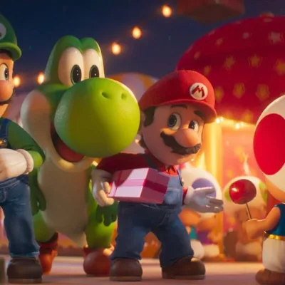 Yoshi entre Mario e Luigi, Mario com um presente, enquanto encaram Toad, de costas, em festa no Reino Cogumelo de noite em "Super Mario Galaxy", o filme.