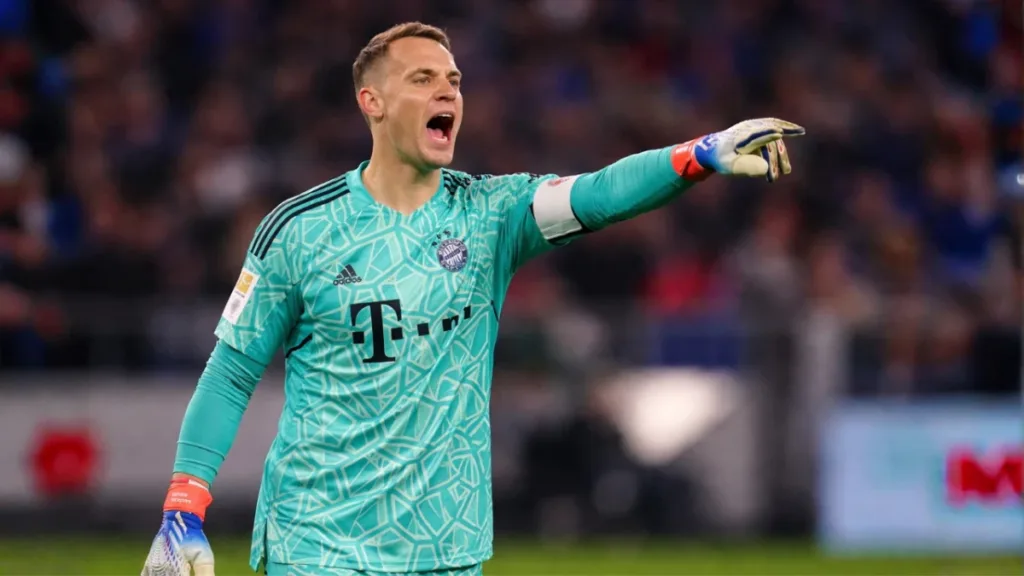 Bayern Vira nos Acréscimos, Elimina o Real Madrid e Avança à Semifinal da Champions 1 Manuel Neuer, braço esquerdo levantado, boca aberta para gritar, com uniforme do Bayern de Munique. Imagem gerada por IA.