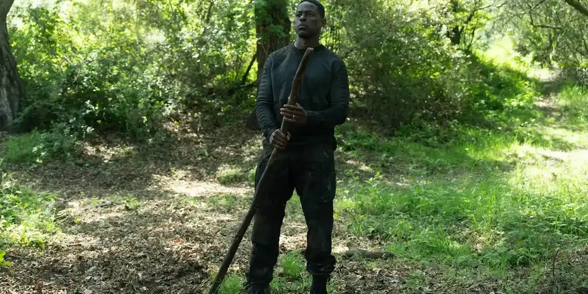 Paradise – 2ª Temporada | Com Nova Temporada Série da Disney+ Traz Novos Personagens e Outra Reviravolta Sterling K. Brown como Xavier Collins na temporada 2, episódio 2, de "Paradise". Ele está com roupas de treinamento, centralizado na foto, no meio de uma floresta, segurando um grande galho.