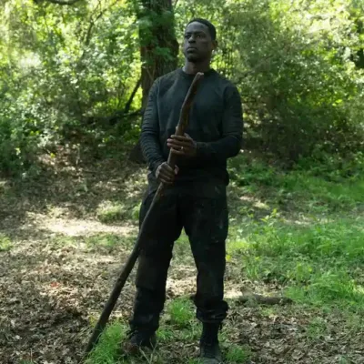 Sterling K. Brown como Xavier Collins na temporada 2, episódio 2, de "Paradise". Ele está com roupas de treinamento, centralizado na foto, no meio de uma floresta, segurando um grande galho.