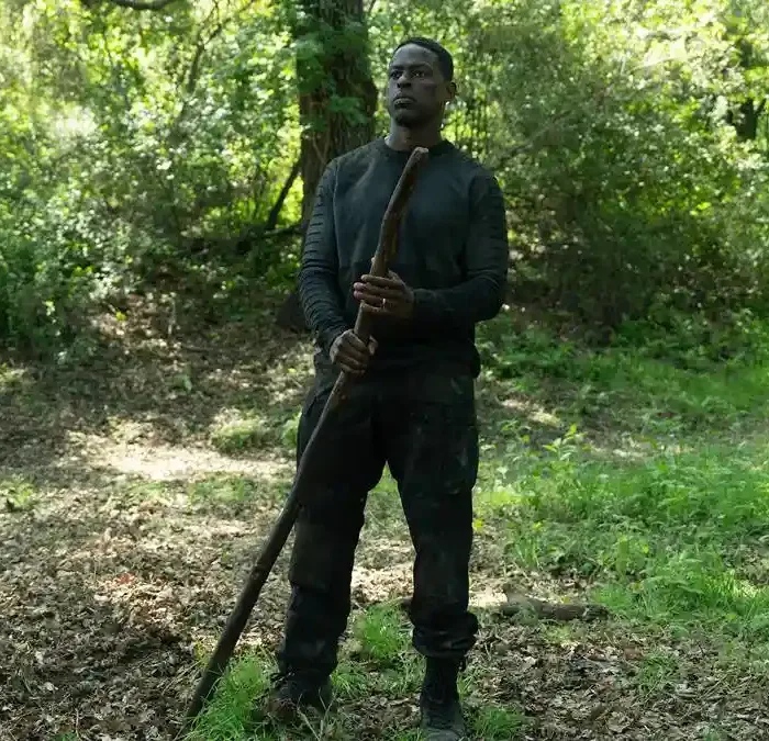 Sterling K. Brown como Xavier Collins na temporada 2, episódio 2, de "Paradise". Ele está com roupas de treinamento, centralizado na foto, no meio de uma floresta, segurando um grande galho.