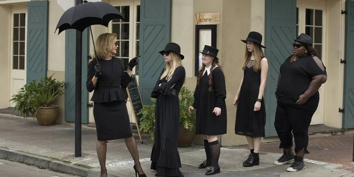 Foto promocional da terceira temporada de "American Horror Story", "Coven". Bruxas, todas de preto, seguem a líder/suprema interpretada por Jessica Lange, à esquerda, pelas calçadas de Nova Orleans.