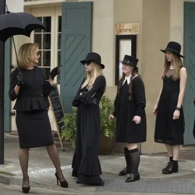 Foto promocional da terceira temporada de "American Horror Story", "Coven". Bruxas, todas de preto, seguem a líder/suprema interpretada por Jessica Lange, à esquerda, pelas calçadas de Nova Orleans.