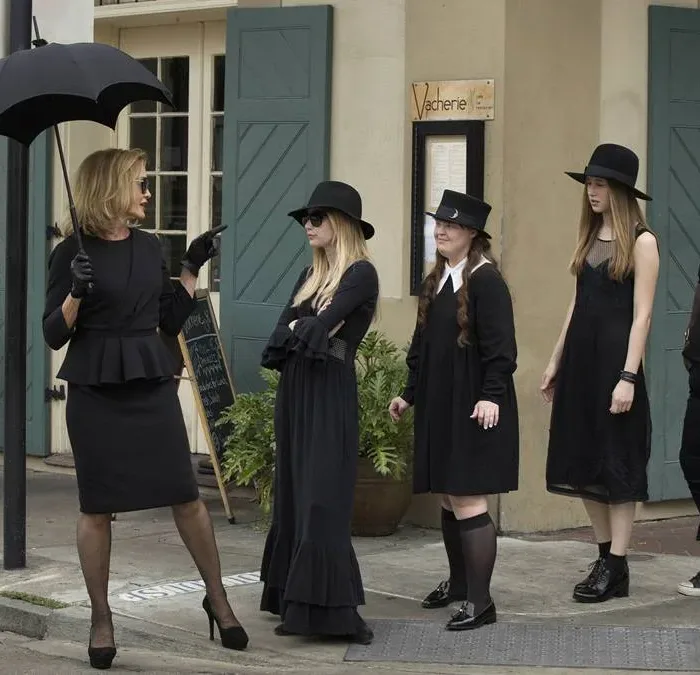 Foto promocional da terceira temporada de "American Horror Story", "Coven". Bruxas, todas de preto, seguem a líder/suprema interpretada por Jessica Lange, à esquerda, pelas calçadas de Nova Orleans.