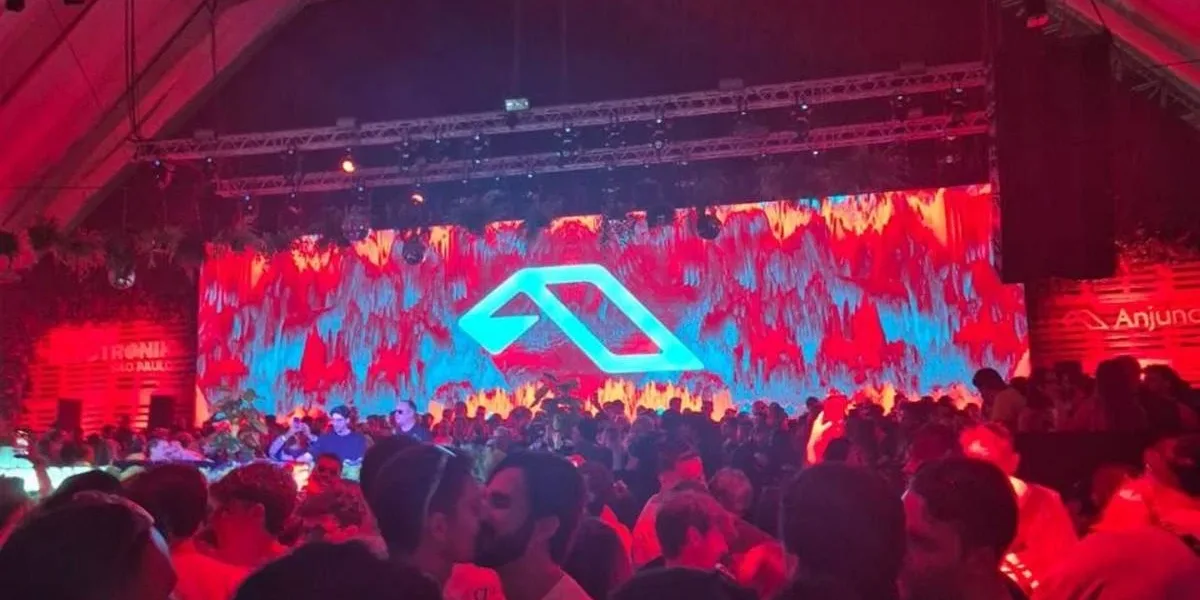 Anjunadeep Open Air São Paulo 2026 | Um Review Feito Por Um Fã Que Acompanha a Cena Foto do primeiro Anjuna Deep Open Air em São Paulo, 2026. Luzes vermelhas no ambiente, telão ao fundo, público aglomerado.