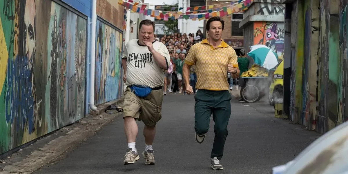 Protagonistas do filme "Balls Up" correndo em uma rua do Brasil durante a copa do mundo.