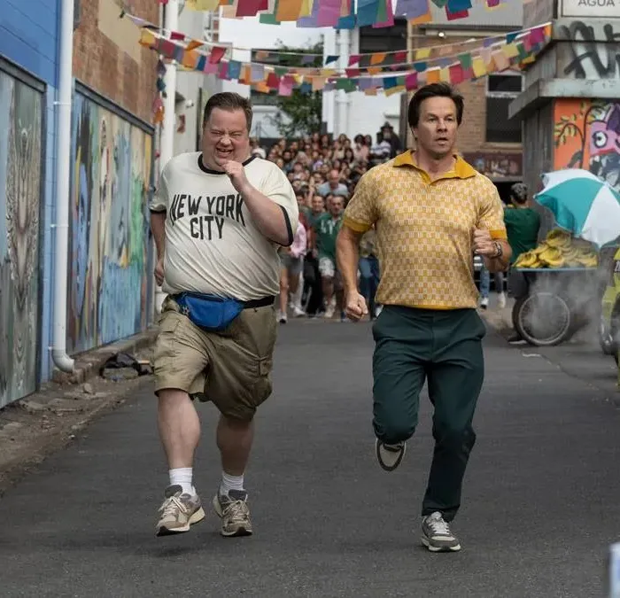 Protagonistas do filme "Balls Up" correndo em uma rua do Brasil durante a copa do mundo.