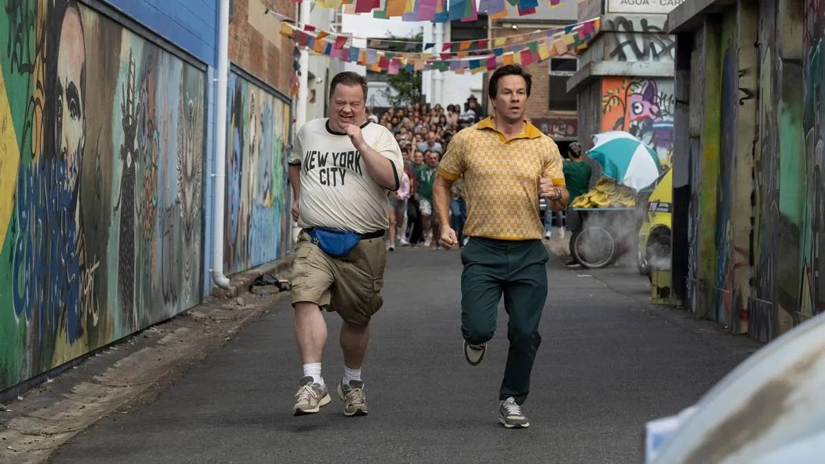 Protagonistas do filme "Balls Up" correndo em uma rua do Brasil durante a copa do mundo.