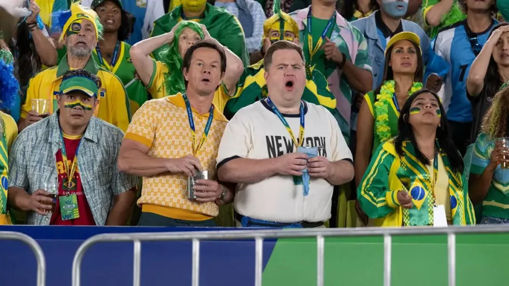 Protagonistas do filme "Balls Up" assistindo uma partida de futebol durante a Copa do Mundo.